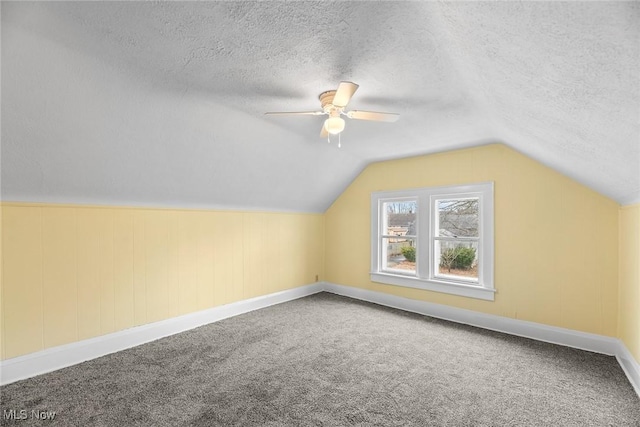 additional living space featuring ceiling fan, lofted ceiling, carpet floors, and a textured ceiling