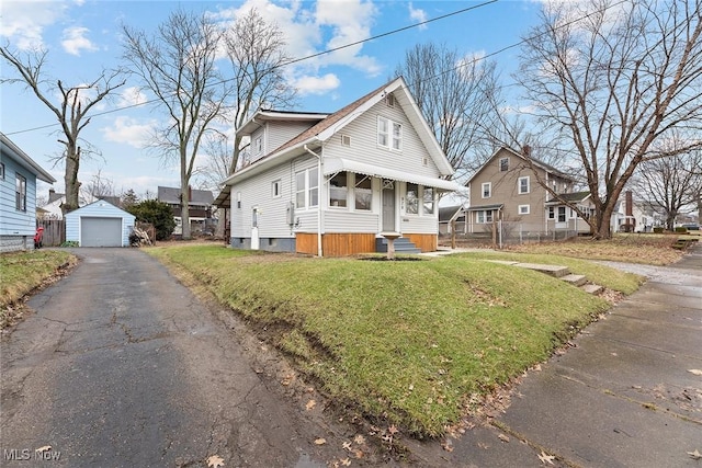 view of front property with an outbuilding, a garage, and a front lawn