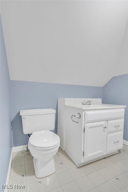 bathroom featuring vanity, vaulted ceiling, and toilet