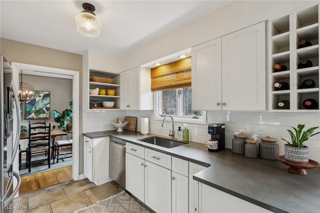 kitchen featuring sink, light tile patterned floors, white cabinets, stainless steel appliances, and backsplash