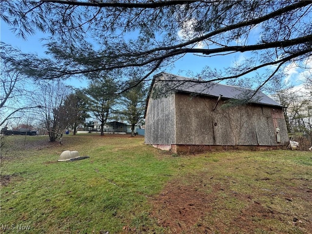 view of side of property featuring an outdoor structure and a lawn