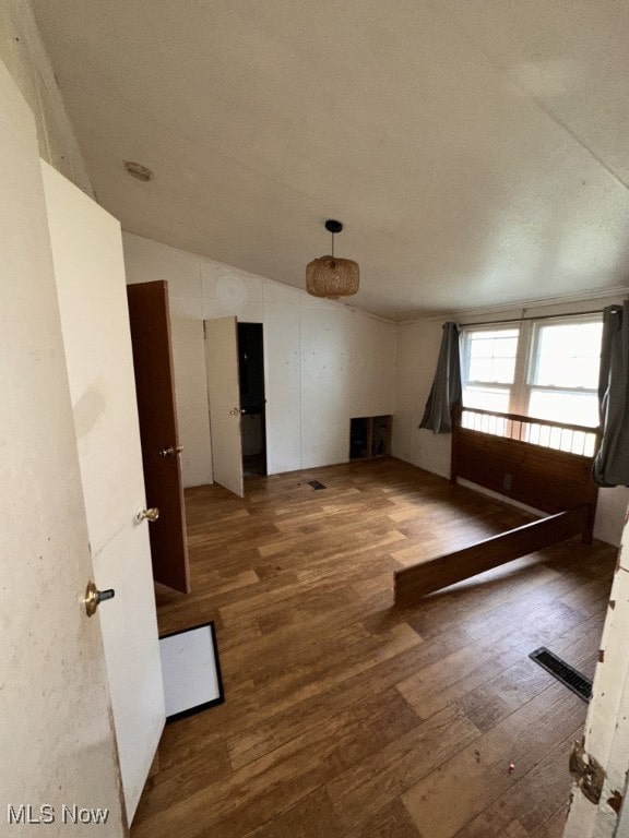 empty room featuring lofted ceiling and dark hardwood / wood-style floors