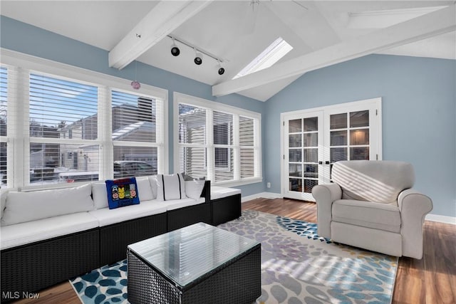 living room featuring lofted ceiling with beams, dark hardwood / wood-style floors, track lighting, and french doors