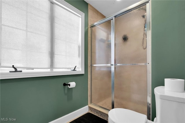 bathroom with toilet and a shower with door