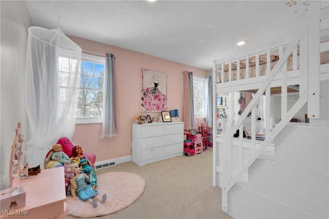 bedroom with multiple windows and light colored carpet