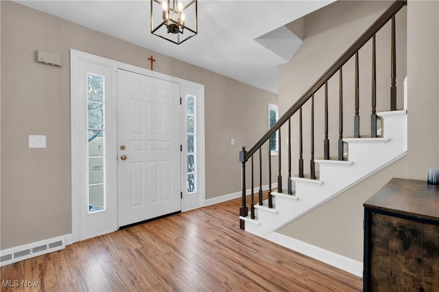 foyer entrance with a notable chandelier, light hardwood / wood-style floors, and a wealth of natural light