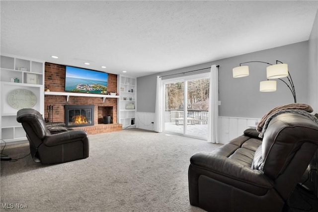 carpeted living room with built in shelves, a brick fireplace, and a textured ceiling