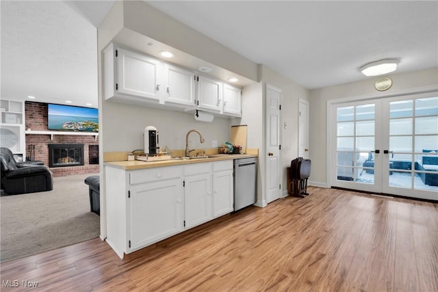 kitchen featuring white cabinetry, sink, stainless steel dishwasher, and french doors