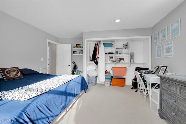 bedroom with light carpet and a closet