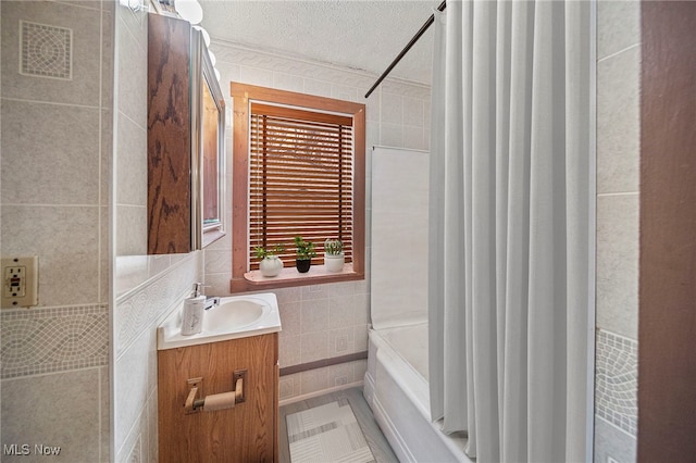 bathroom featuring shower / tub combination, tile walls, vanity, tile patterned floors, and a textured ceiling