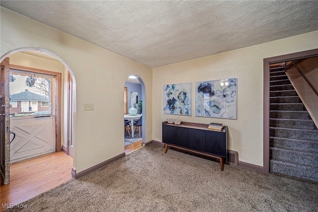 entrance foyer with carpet and a textured ceiling