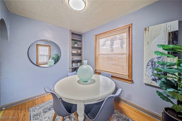 dining room featuring hardwood / wood-style flooring and a textured ceiling