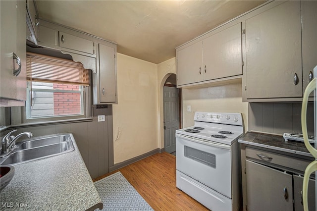 kitchen featuring electric stove, sink, gray cabinets, and light wood-type flooring