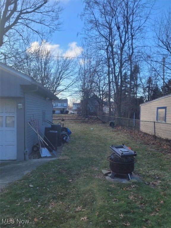 view of yard with a fire pit and a garage