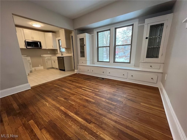 kitchen with white cabinets, light hardwood / wood-style flooring, and dishwasher