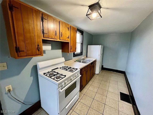 kitchen featuring white appliances, sink, and light tile patterned floors