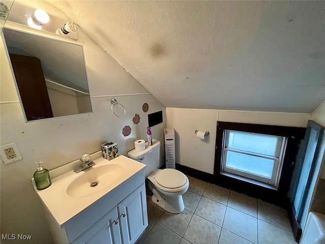 bathroom featuring tile patterned floors, toilet, vaulted ceiling, a textured ceiling, and vanity