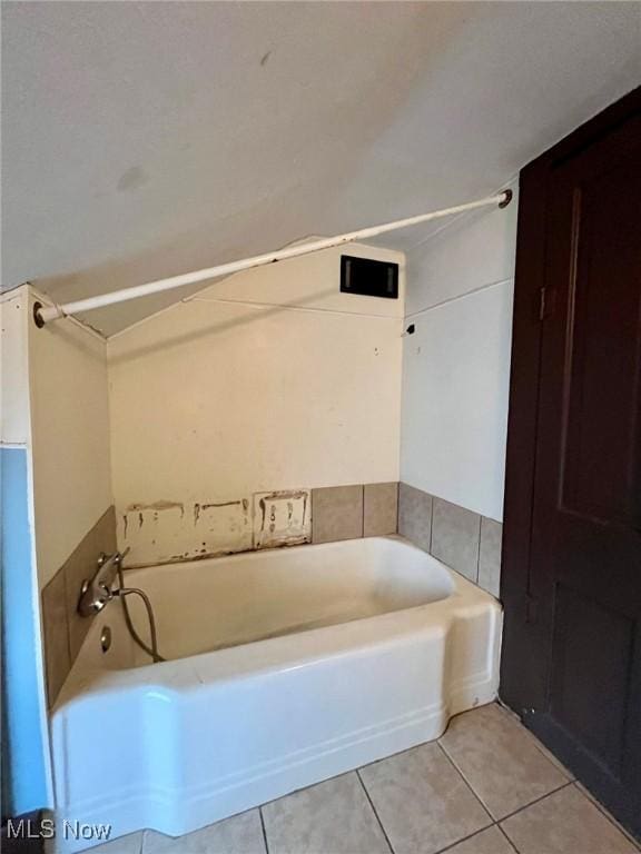 bathroom with a bathing tub and tile patterned flooring