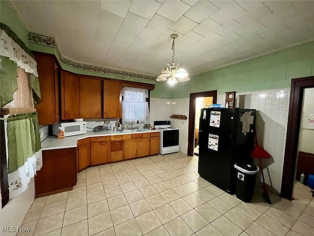 kitchen with decorative light fixtures, sink, light tile patterned floors, white appliances, and an inviting chandelier