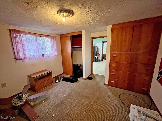 bedroom featuring light carpet, a closet, and a textured ceiling