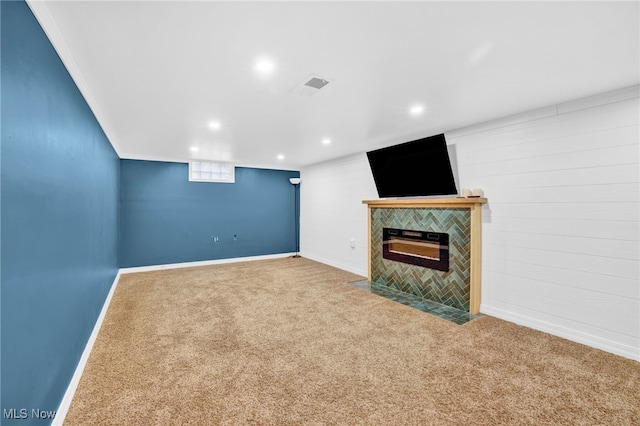 basement with a tiled fireplace and carpet