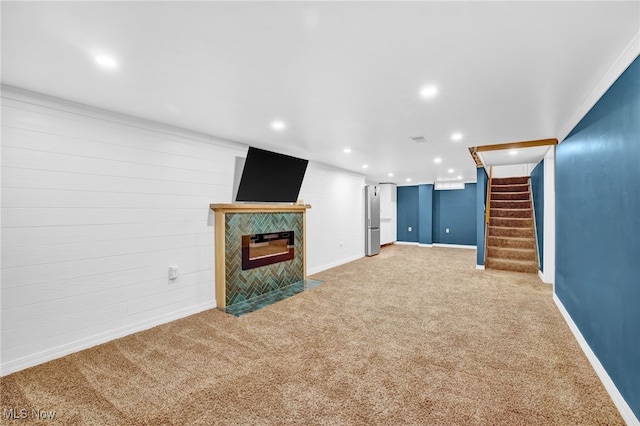 unfurnished living room featuring a tiled fireplace and carpet