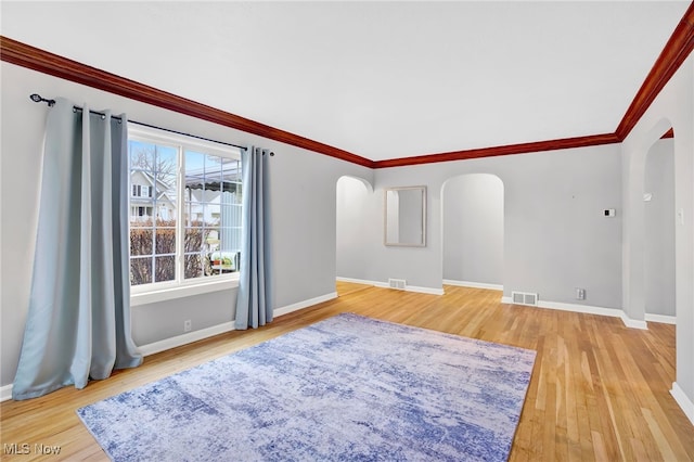 empty room featuring crown molding and hardwood / wood-style flooring