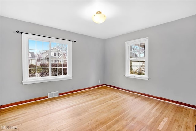 unfurnished room featuring hardwood / wood-style flooring and a wealth of natural light