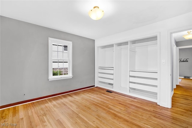 unfurnished bedroom featuring hardwood / wood-style flooring and a closet