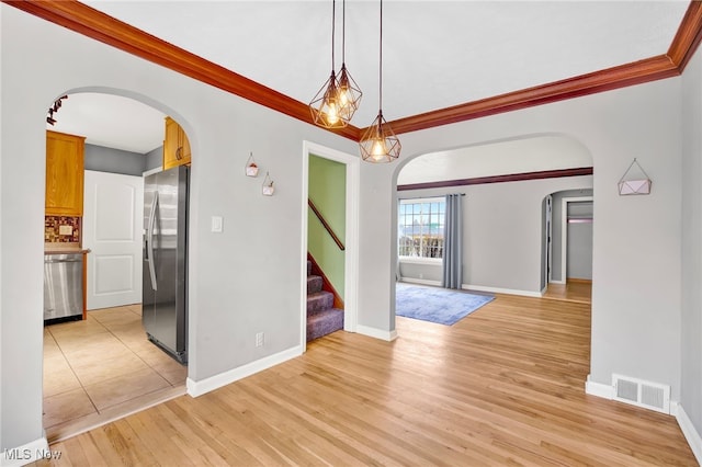 interior space with crown molding and light wood-type flooring