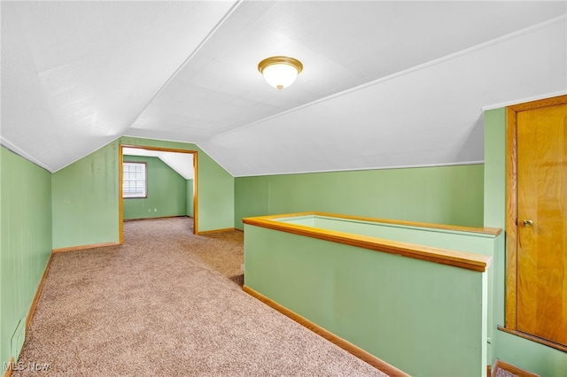 additional living space featuring vaulted ceiling and light carpet