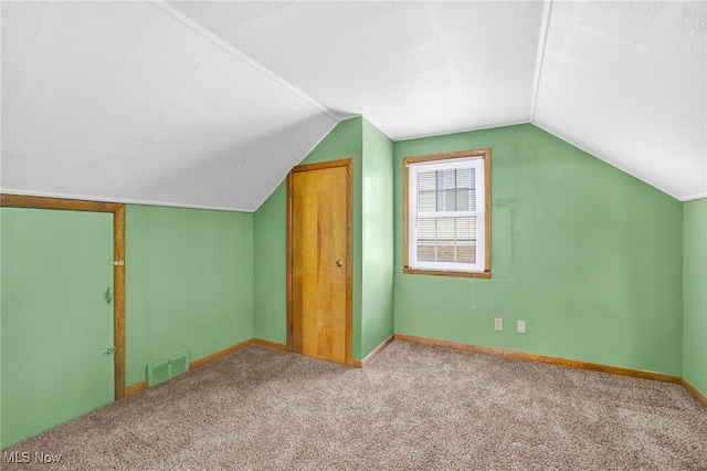 additional living space featuring carpet flooring and vaulted ceiling