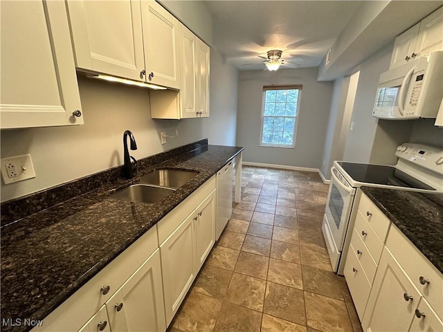 kitchen with sink, white cabinets, dark stone counters, ceiling fan, and white appliances