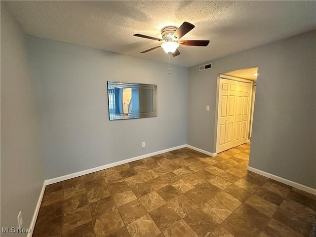 spare room featuring a textured ceiling and ceiling fan