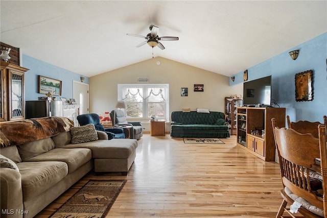 living room featuring lofted ceiling, ceiling fan, and light wood-type flooring