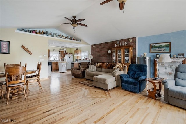 living room with vaulted ceiling, ceiling fan, sink, and light hardwood / wood-style floors