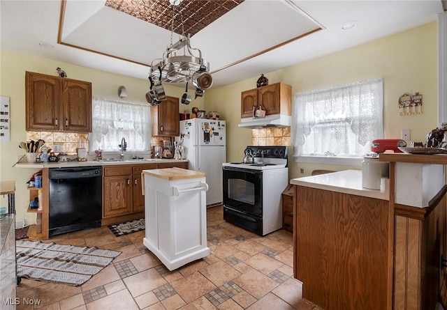 kitchen with electric stove, sink, a center island, black dishwasher, and white refrigerator