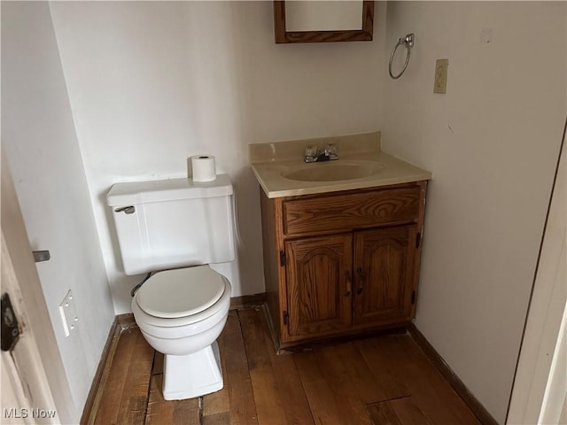 bathroom featuring vanity, hardwood / wood-style floors, and toilet