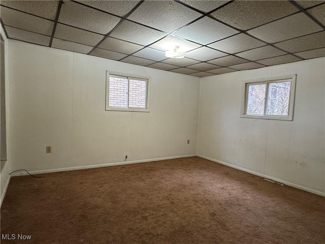 basement with a paneled ceiling, carpet, and a wealth of natural light