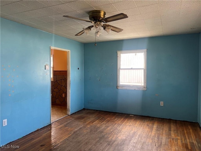 empty room with ceiling fan and dark hardwood / wood-style flooring