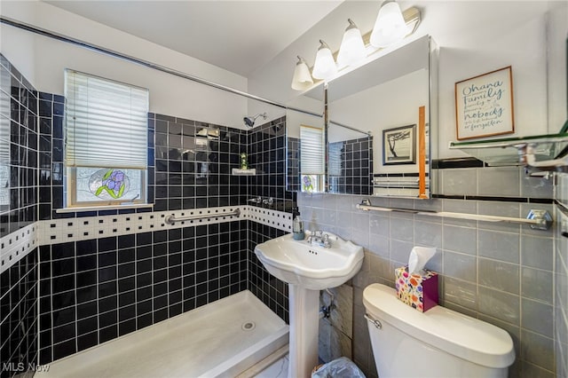 bathroom featuring tiled shower, toilet, and tile walls