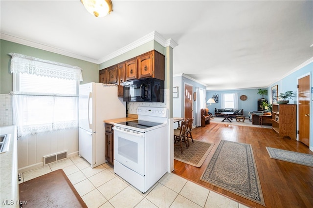 kitchen with crown molding, white appliances, light hardwood / wood-style flooring, and decorative backsplash