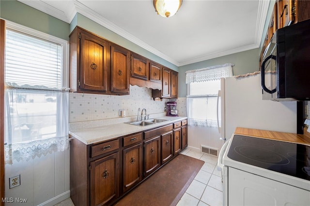 kitchen featuring ornamental molding, sink, light tile patterned floors, and electric range