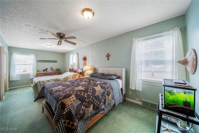 bedroom with ceiling fan, carpet flooring, and a textured ceiling