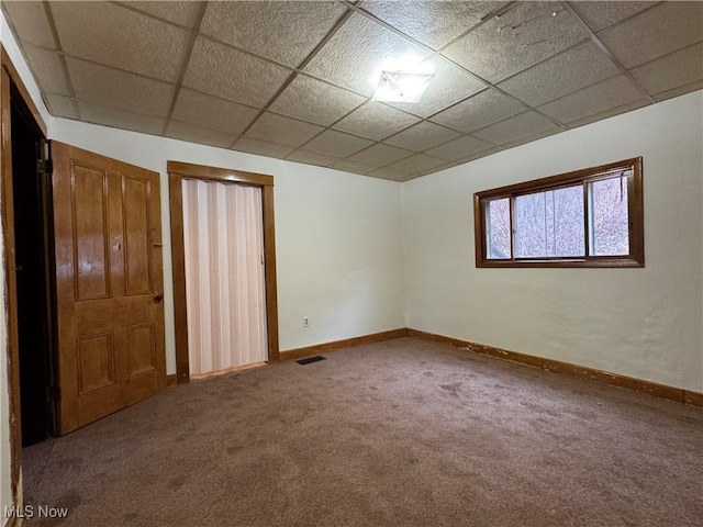 spare room with a drop ceiling and carpet flooring