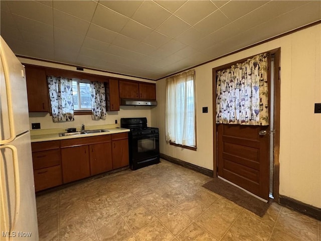 kitchen featuring white refrigerator, sink, and black range with gas stovetop