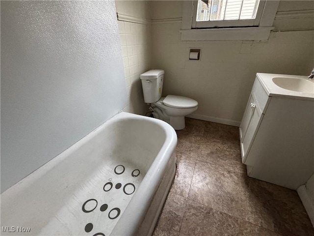 bathroom with vanity, a tub, and toilet