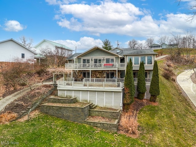 rear view of property with a deck and a lawn