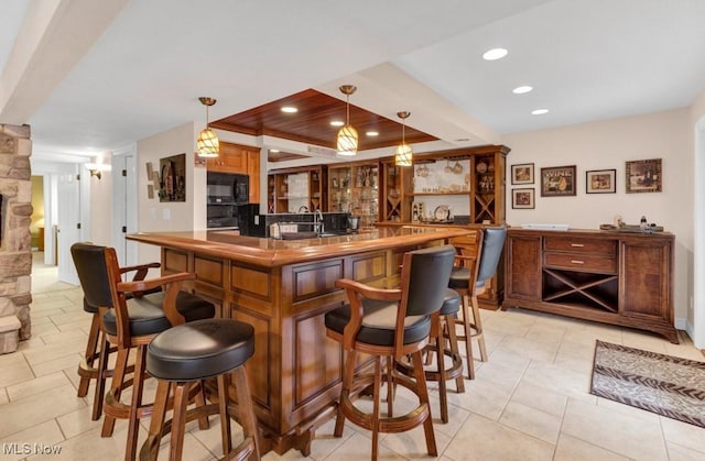 bar with a fireplace, hanging light fixtures, and light tile patterned floors