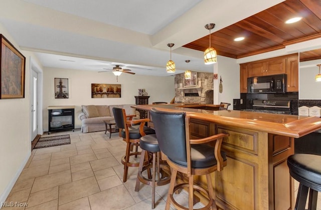 kitchen featuring range, wooden ceiling, a kitchen breakfast bar, pendant lighting, and backsplash